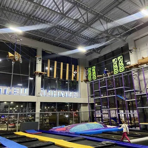 Тренировка на батуте в спортивном центре с высоким потолком и современным оборудованием