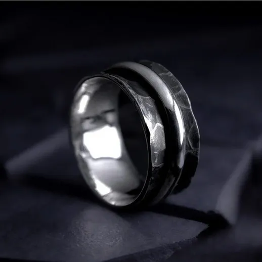 Элегантное серебряное кольцо на темном фоне с текстурированной поверхностью