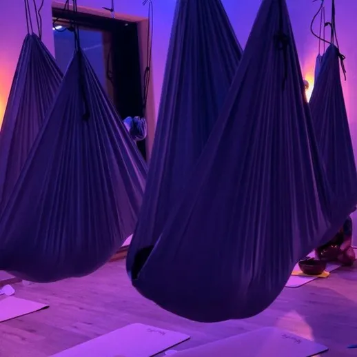 Подвесные гамаки для йоги в студии с мягким освещением на горизонте