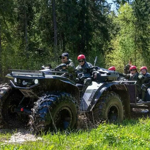 Военная техника в лесу: группа солдат едет на многофункциональном транспортном средстве в зеленом окружении