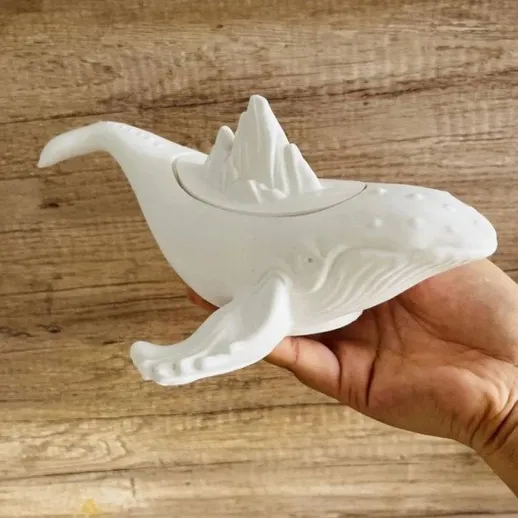 Фигура кита с горой в руках человека в интерьере