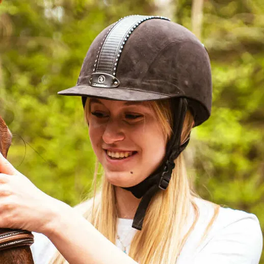 Молодая женщина гладит лошадь на ферме в лесной местности в светлый день Молодая женщина гладит лошадь на ферме в лесной местности в светлый день