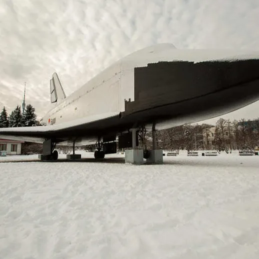 Экспонат космического корабля на фоне зимнего пейзажа в музейном комплексе