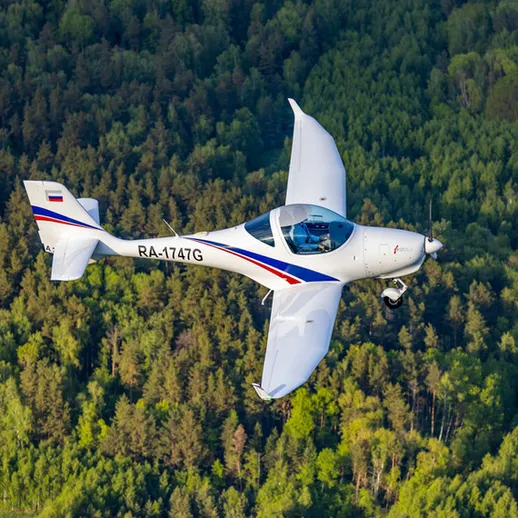 Маленький летательный аппарат над зелеными лесами России в ясный день