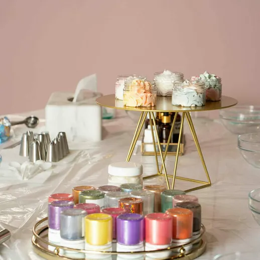 Украшение тортов с красочными кремами и аксессуарами на столе в кондитерской