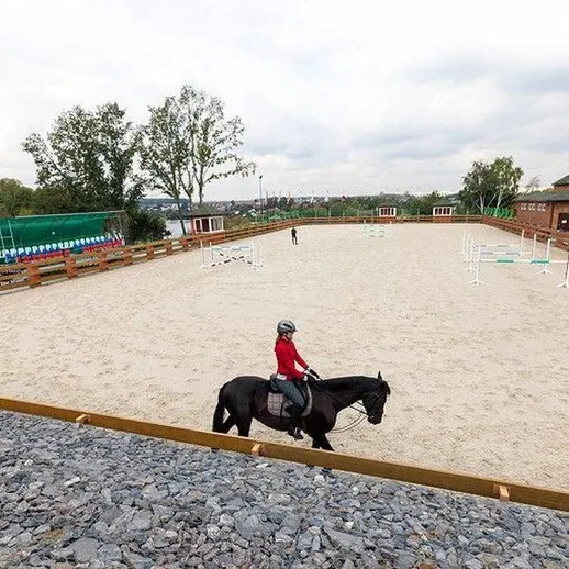 Конная езда на открытой арене в загородном клубе в пасмурный день