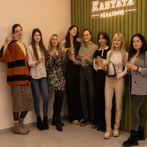 Женская встреча в Академии Кантака, где участницы празднуют с напитками в современных интерьерах