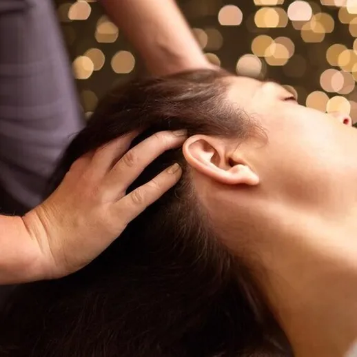 Расслабляющий массаж шеи и головы в уютном салоне здоровья с теплым освещением
