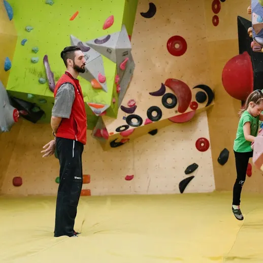 Тренировка юного скалолаза на скалодроме в солнечный день