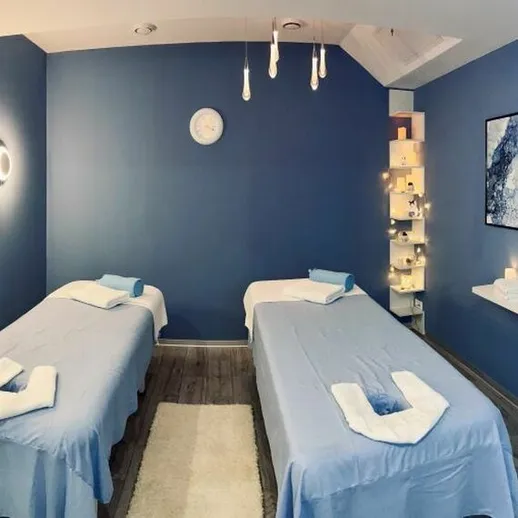 Уютный спа-салон с массажными столами и атмосферным освещением для релаксации в спокойной обстановке