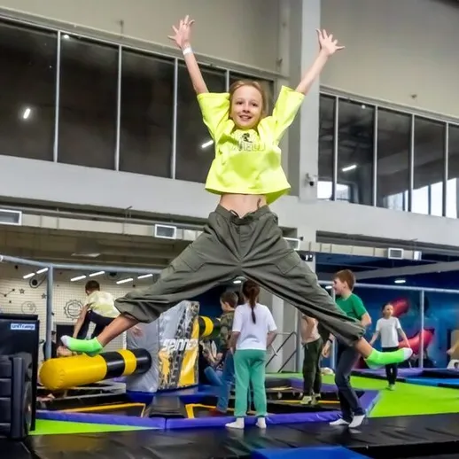 Подросток с радостью прыгает на батуте в современном развлекательном центре в Москве
