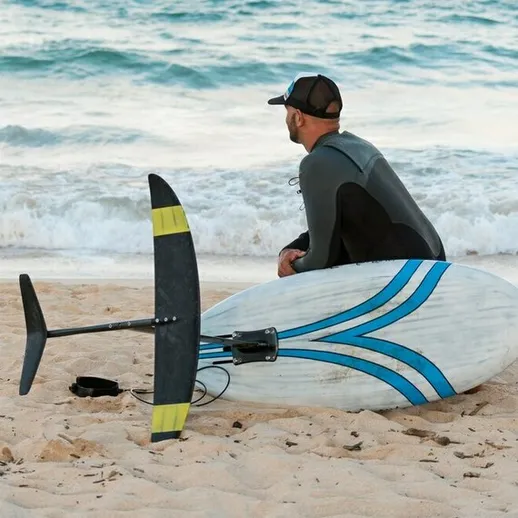 Серфингист на берегу моря ожидает подходящей волны для катания на фойле