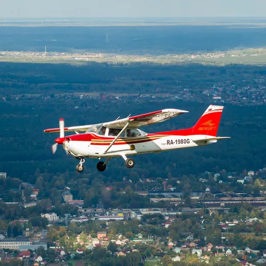Самолёт Cessna над городом в ясный день, частный полёт, мирная атмосфера, осень 2023 года