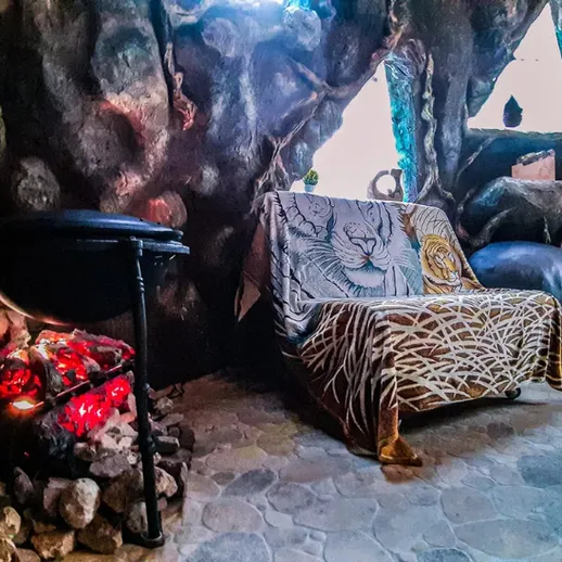 Уютный уголок с камином в доме, украшенном живописной стеной, создающий атмосферу тепла и покоя