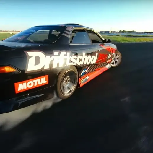 Дрифт на треке с автомобилем учебной школы дрифта в ясный день