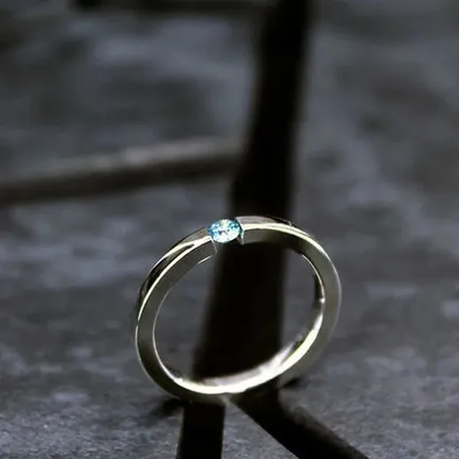 Изящное кольцо с бриллиантом, созданное для особых моментов, на темном фоне и при мягком освещении