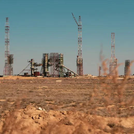 Строительство нефтяной платформы в пустыне с подъемными кранами на фоне ясного неба