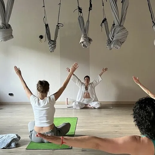 Йога занятия в современном студии, участники выполняют растяжку и медитацию под руководством инструктора