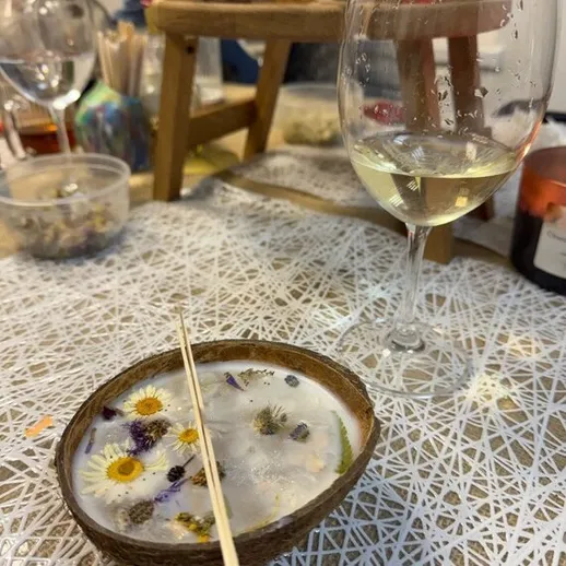 На столе лежит коктейль с цветами и стакан вина