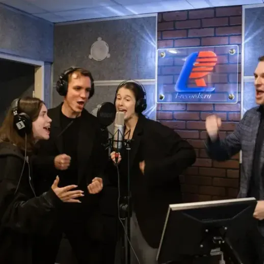 Спontанным способом команда поёт в звукозаписывающей студии в вечернее время