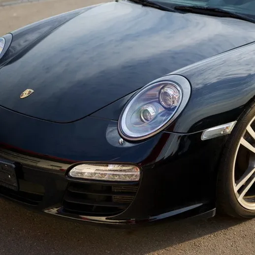 Черный спортивный автомобиль на улице, в ясный день, демонстрирует элегантный дизайн и мощные характеристики