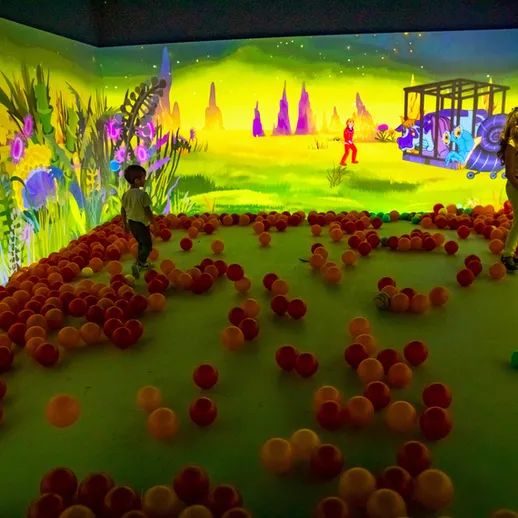 Дети играют в интерактивном пространстве с разноцветными шарами в современном игровом центре