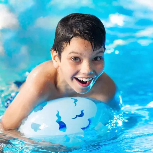 Мальчик играет в бассейне с надувным кругом в ясный день