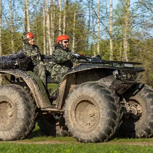 Квадроцикл с пассажирами на фоне леса в ясный день, активный отдых на природе