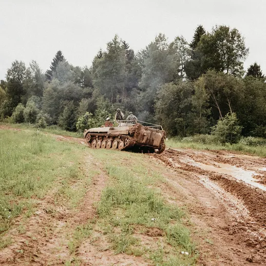 Боевая техника преодолевает труднопроходимую местность на тренировочных занятиях в лесу под дождем
