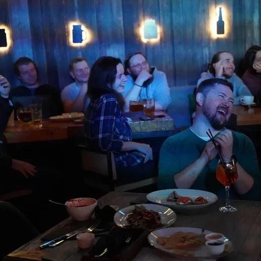 Смешная комедия в баре: зрители смеются и наслаждаются вечером в уютном заведении