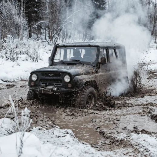 Автомобиль в грязи на зимней трассе в лесу