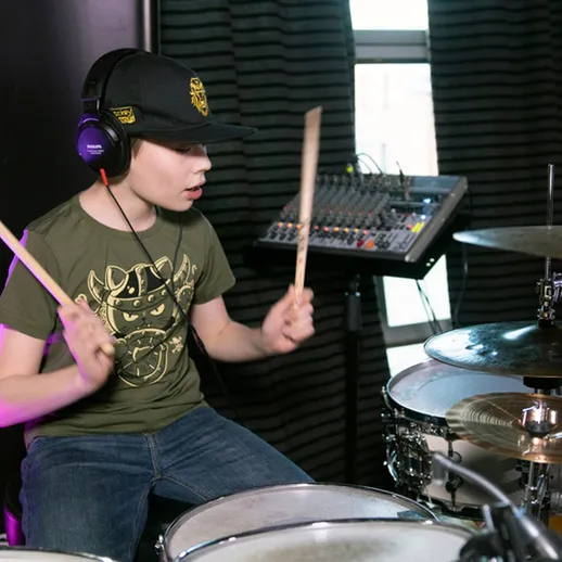 Молодой барабанщик исполняет талантливое выступление в студии звукозаписи