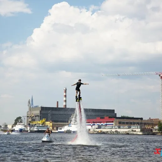 Мужчина выполняет трюки на водном дроне у берегов реки в солнечный день