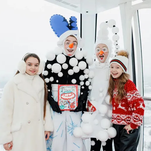 В праздничной обстановке дети встречают Новый год в зимнем наряде на смотровой площадке