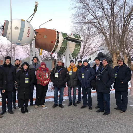 Группа людей у большого космического объекта в зимний день в России