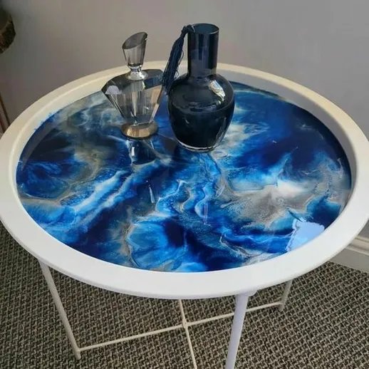 Стильный круглый стол с голубым эпоксидным покрытием и декором из стеклянных сосудов