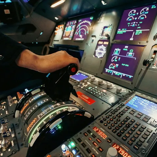 Кабина пилота современного самолета с управляющим рычагом и приборами на панели в процессе полета