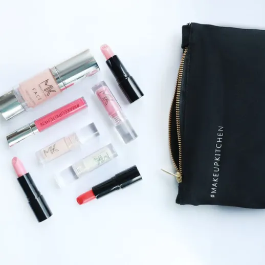 Косметика и сумка находятся на белом фоне с различными средствами для макияжа