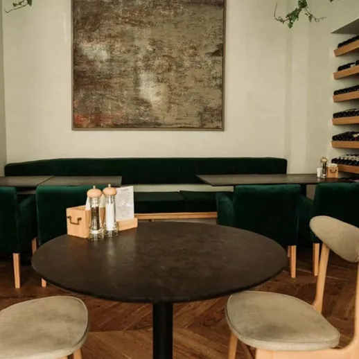 Уютный ресторан в центре города с зелеными креслами и стильным интерьером