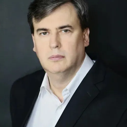 Портрет зрелого человека в официальном костюме на фоне нейтрального цвета, сфотографированного в студии в вечернее время