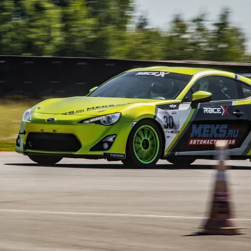 Яркий спортивный автомобиль на автодроме во время гонки в солнечный день