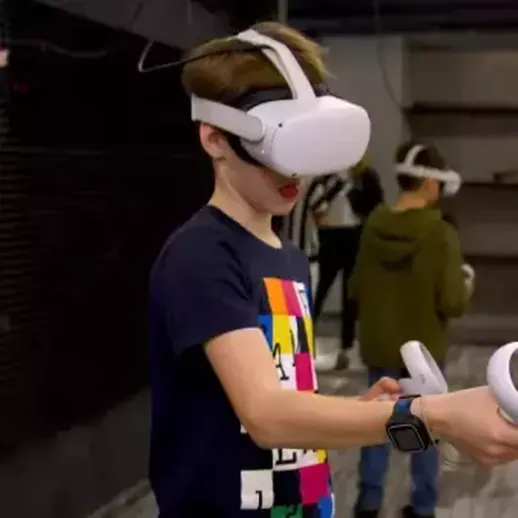 Молодой человек в виртуальной реальности исследует цифровое пространство в игровой арене в вечернее время