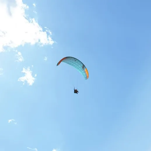 Парапланерист кардинально меняет свой взгляд на мир, паря над живописным пейзажем под ясным небом