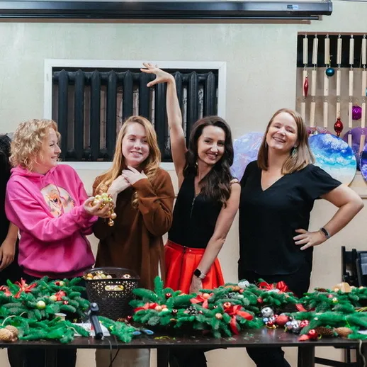 Группа друзей собирается на рождественское мероприятие в уютной обстановке, украшая стол гирляндами