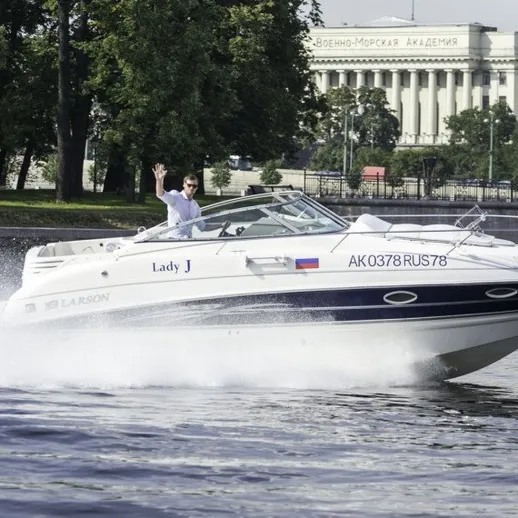 На реке моторная лодка на высокой скорости около здания академии в Москве