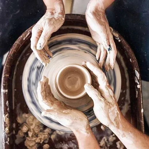 Изготовление глиняной посуды на гончарном круге в мастерской с участием нескольких человек