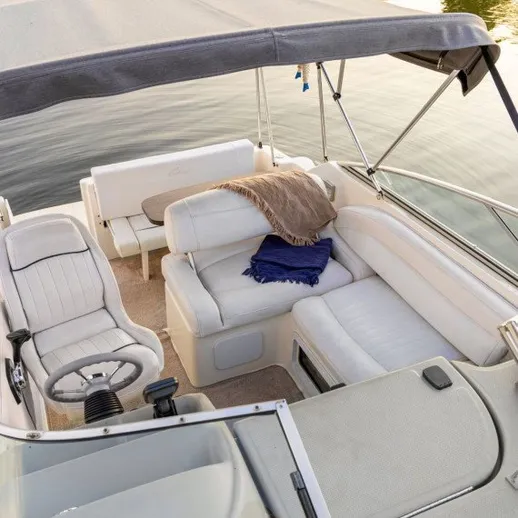 Корабль на воде с мягкими диванами и рулем на солнечном день
