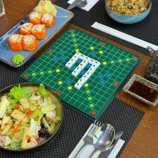 Вкусный ужин с суши и салатами на столе с настольной игрой рядом в уютном ресторане