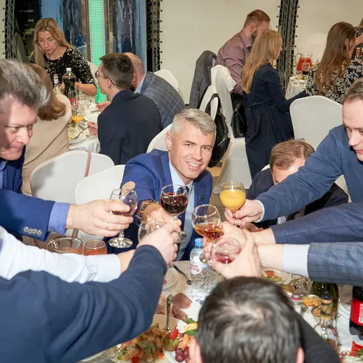 Праздничный банкет с тостами и радостными лицами в уютном ресторане