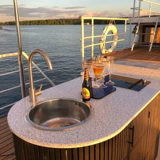 Уютный бар на палубе с напитками у воды на закате